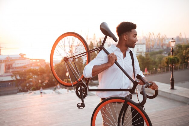 Concentrated young african man in early morning with bicycle