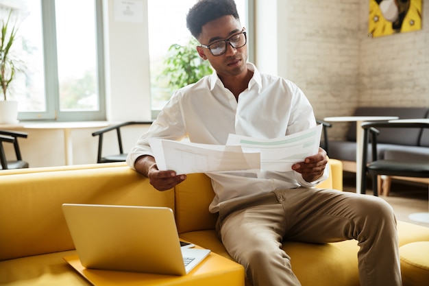 Concentrated young african man sitting coworking