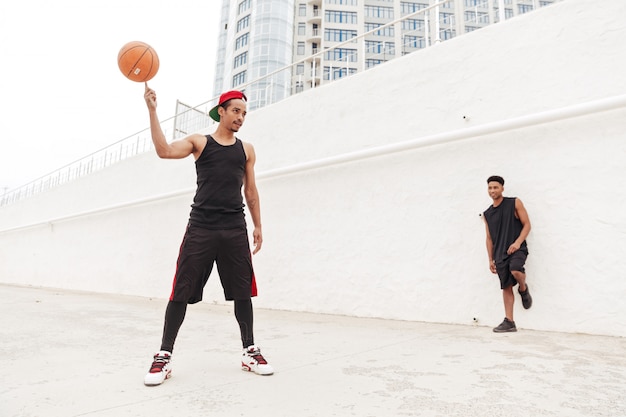 Free Photo concentrated young african sports men play basketball