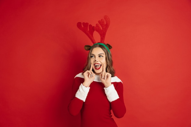 Free Photo concept of christmas, new year's, winter mood, holidays. beautiful caucasian woman with long hair like santa's reindeer catching giftbox.