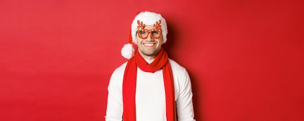 Free Photo concept of christmas winter holidays and celebration cheerful handsome guy in new year party glasses...