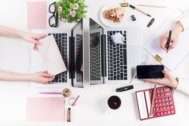 Concept of comfortable male and female workplaces. Gadgets on the white desk