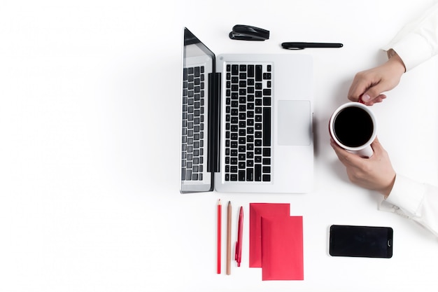 Concept of comfortable workplaces. Hands and gadgets on the white desk