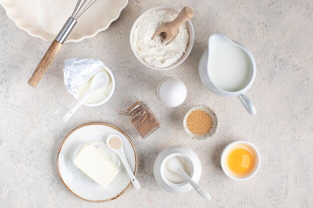 The concept of home baking Ingredients for making dough cake cupcakes eggs flour butter cinnamon milk sugar on a light background