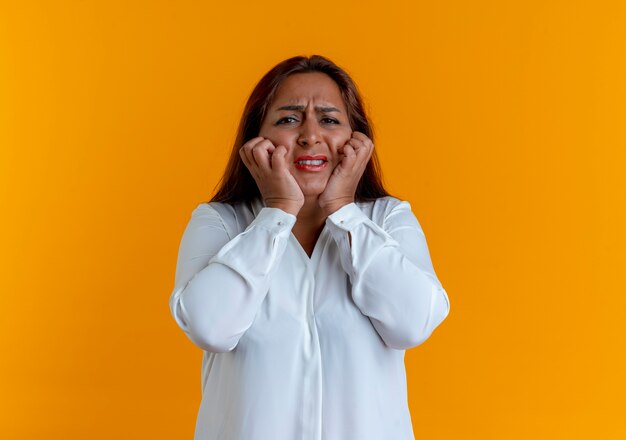 Concerned casual caucasian middle-aged woman grabbed cheeks 