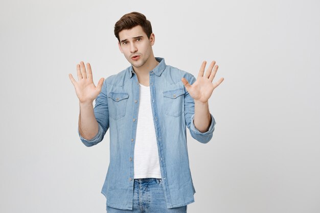 Concerned man showing stop gesture, refusing bad offer