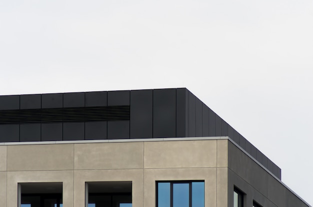 A concrete building with mirror windows under the clear sky