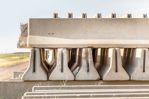 Concrete parts piled up besides a rural road besides the highway