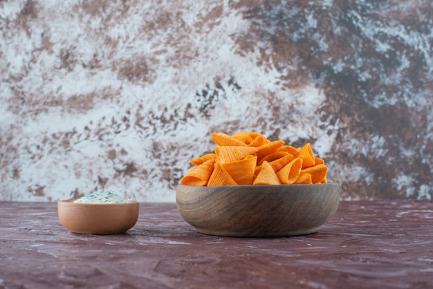 Free photo cone chips in a bowl with yogurt in a bowl on the marble surface