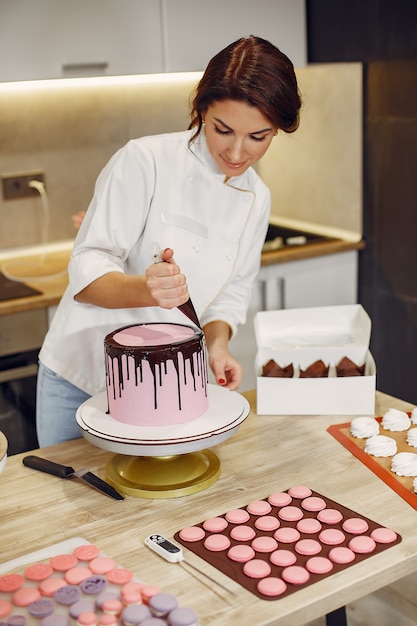 Free Photo confectioner in a uniform decorates the cake