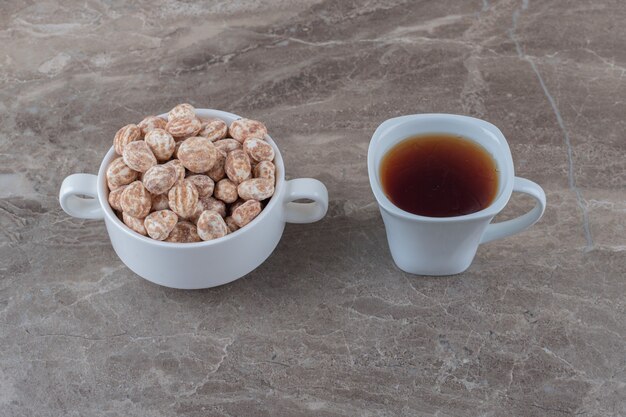 Confectionery and cup of tea on the marble surface