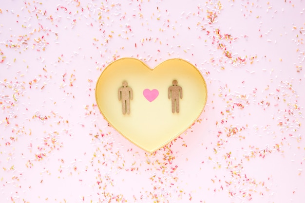 Free photo confetti around heart with gay couple