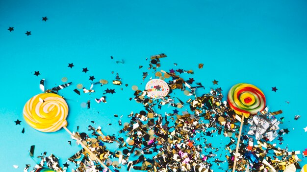 Confetti and lollipops on blue background