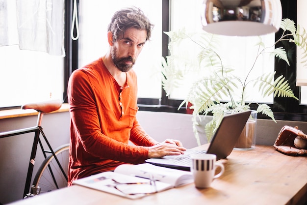 Free photo confident adult man posing at table