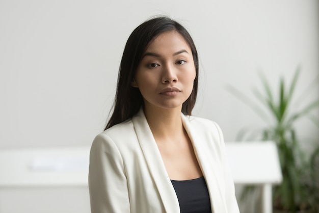 Confident attractive asian businesswoman looking at camera, head shot portrait