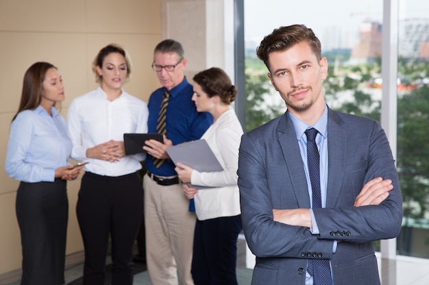 Free photo confident business leader with team in background