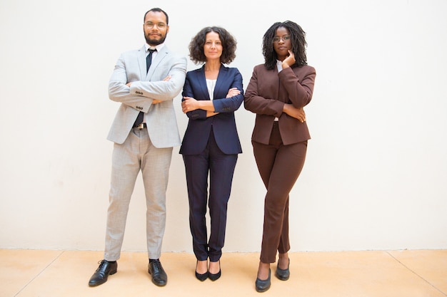 Confident business people posing with arms folded