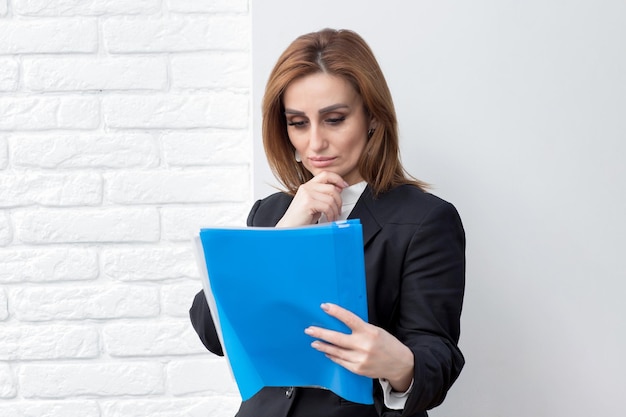 Confident business woman holding her notebook and looking at it