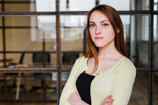 Free Photo confident businesswoman looking at camera with arm crossed