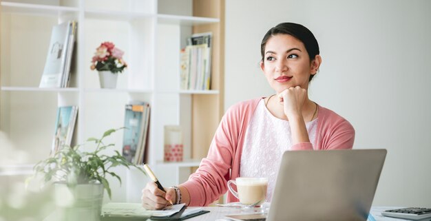 Confident Businesswoman Smiling and thinking Sitting In Modern Office.