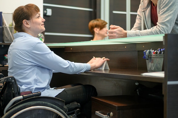 Free photo confident businesswoman in wheelchair at the office