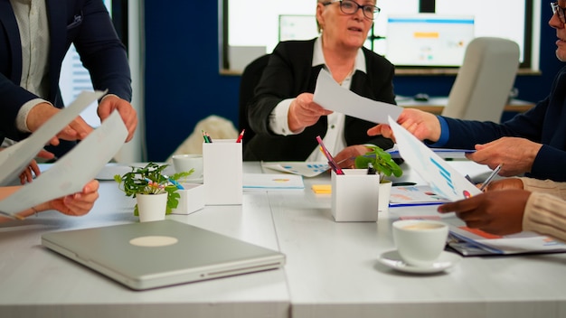 Free Photo confident company manager giving working tasks to diverse teamworkers analysing paperwork with graphs sitting in start up office. multiethnic team discussing project ideas at brainstorming meeting