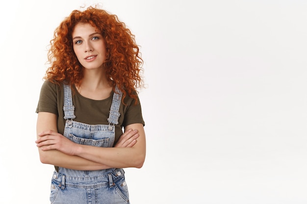 Confident empowered good-looking redhead curly-haired girl, cross arms and smiling self-assured at camera, know her work, giving professional vibes, standing ambitious, determined win