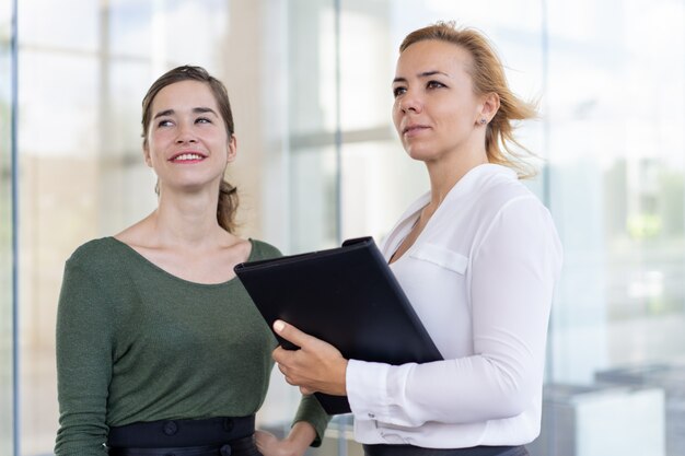 Confident estate agents admiring neighbor building