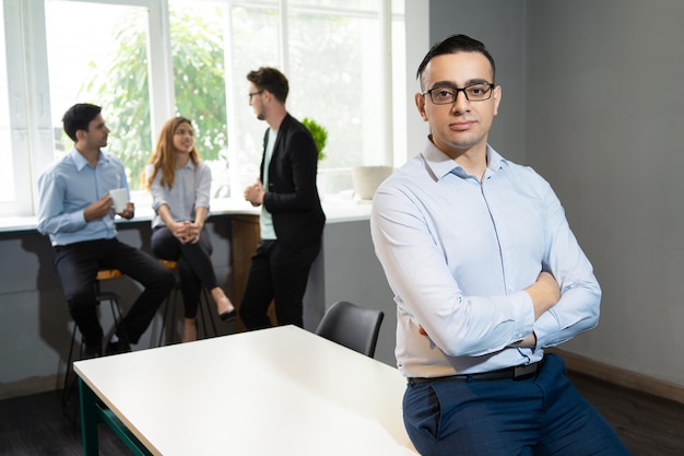 Confident handsome business leader posing in meeting room