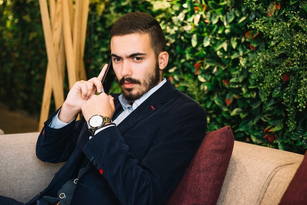 Free photo confident handsome man talking on phone