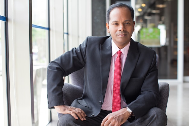 Confident Indian Business Man Sitting in Armchair