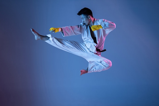 Confident korean man in kimono practicing handtohand combat martial arts