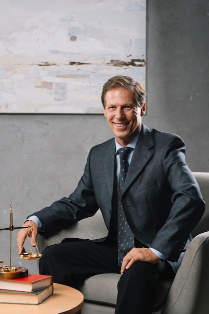 Confident male mature lawyer sitting in office