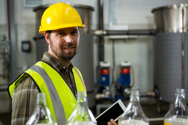 Confident male worker holding digital tablet in factory