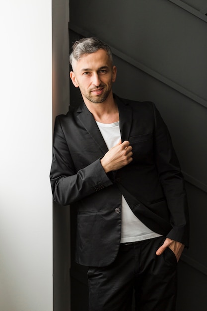 Free photo confident man leaning on a wall