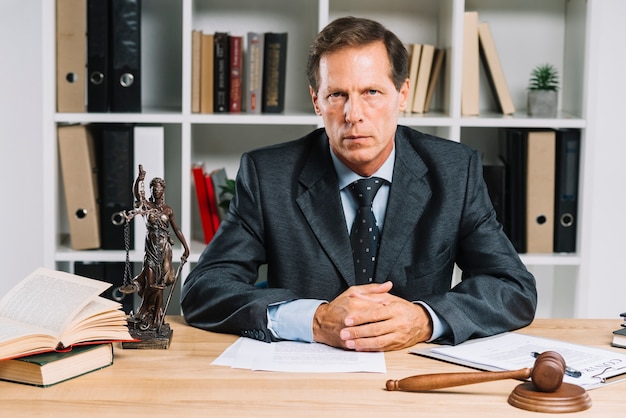 Confident mature lawyer sitting in courtroom