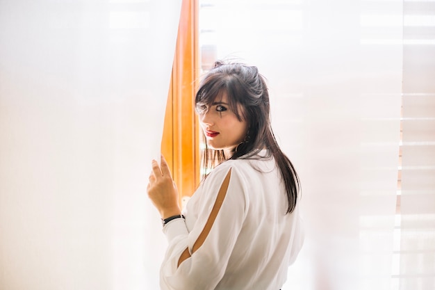 Confident model standing near window