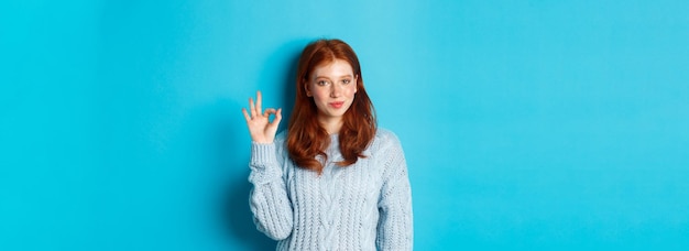 Free photo confident redhead girl assuring you showing okay sign and smiling saying yes approve and agree stand