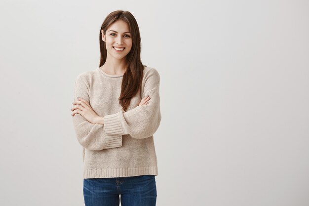 Confident satisfied female customer smiling with cross arms chest pleased