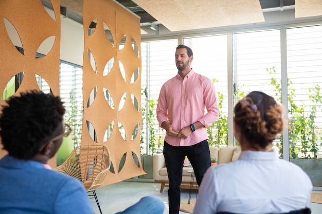 Free photo confident team leader talking to colleagues