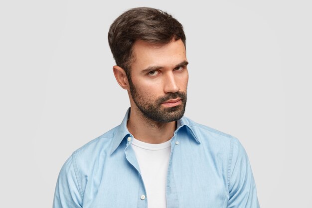 Confident unshaven guy with dark bristle and hair, listens attentively boss