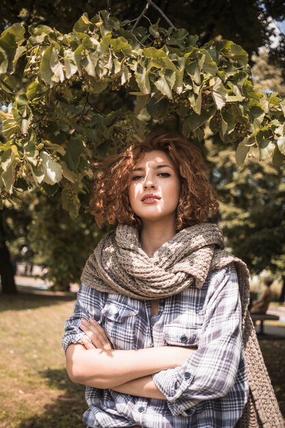 Confident woman standing under tree