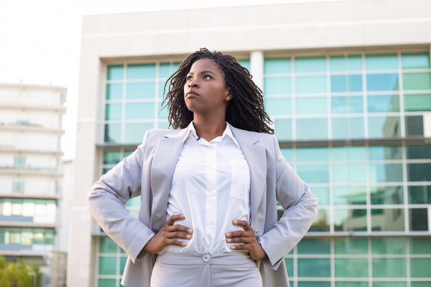 Confident young businesswoman with hands on waist