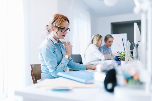 Free photo confident young businesswoman working on laptop in office