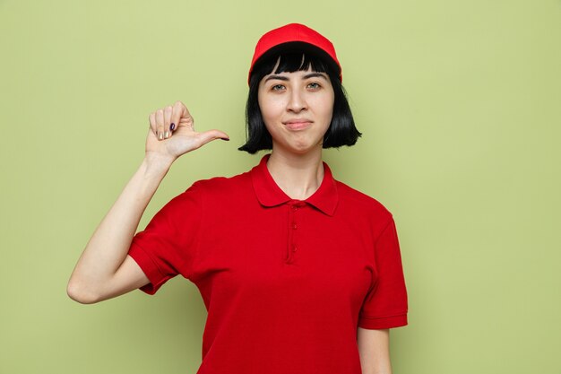 Confident young caucasian delivery woman pointing at herself 