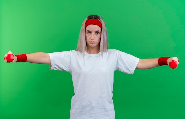 Free photo confident young caucasian sporty girl with braces wearing headband