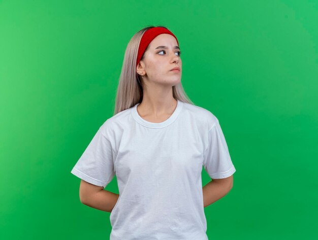 Confident young caucasian sporty girl with braces wearing headband