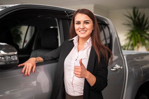 Confident young girl holding thumb up