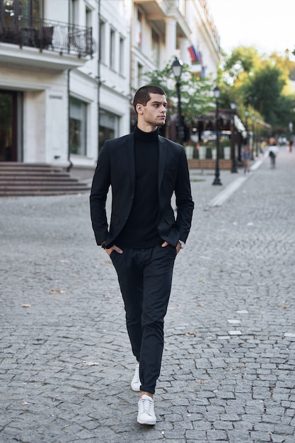 Confident young man walking on a European city street