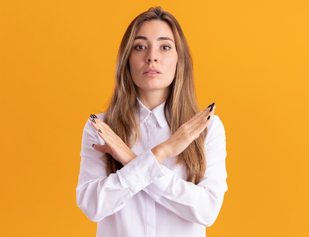 Free photo confident young pretty caucasian girl crosses hands gesturing no sign isolated on orange wall with copy space